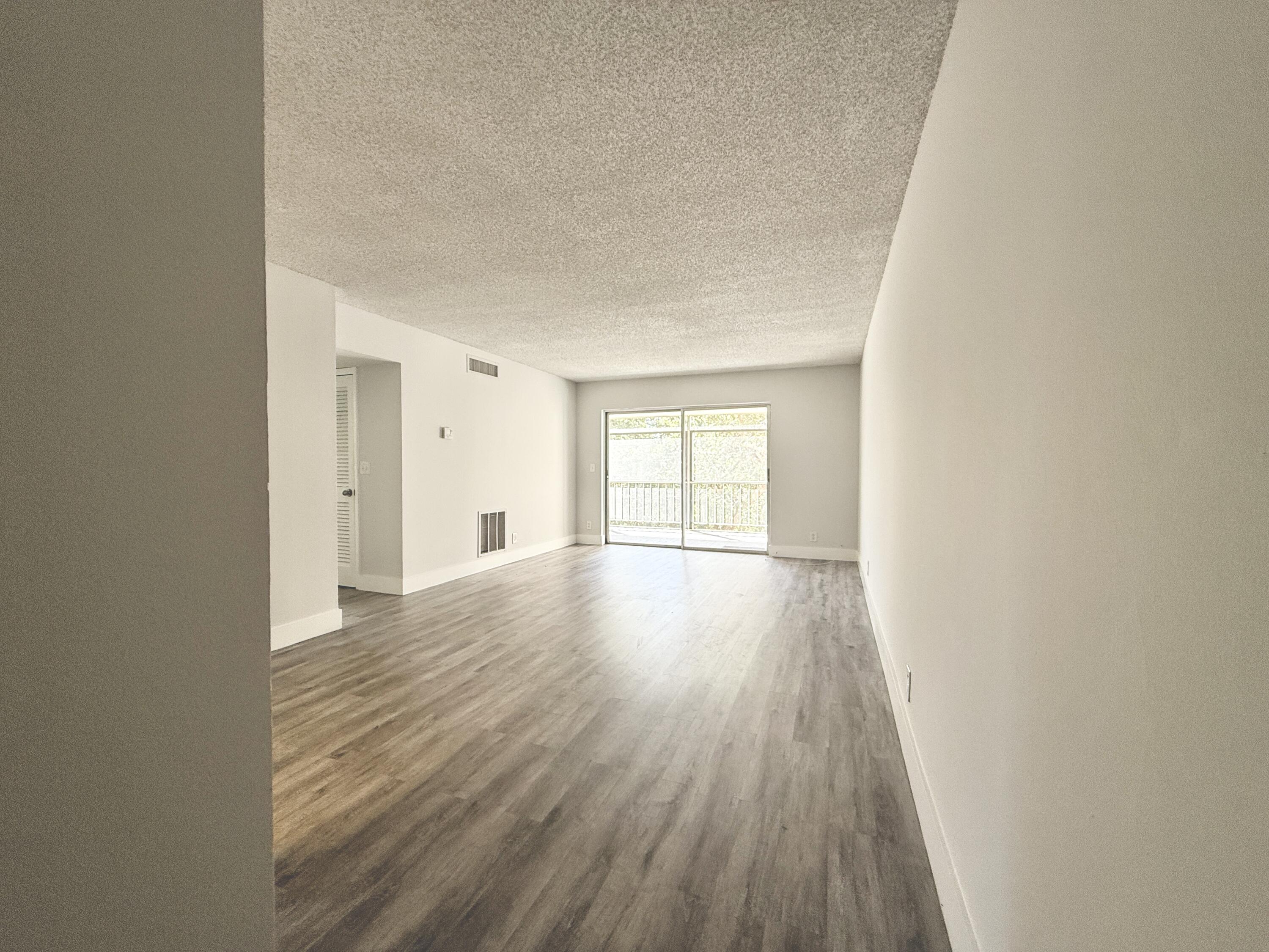 a view of an empty room and wooden floor