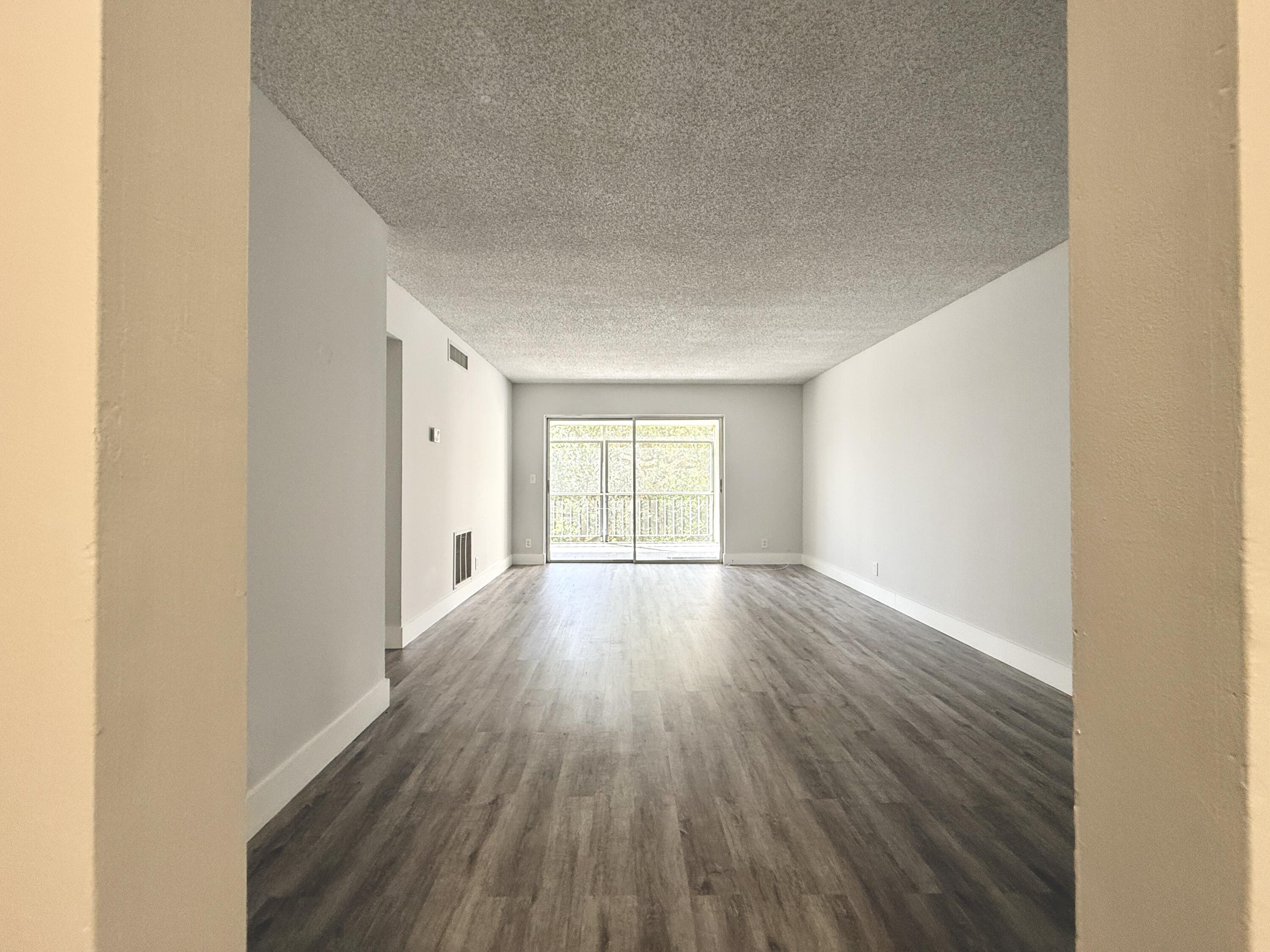 604 Northwest 13th Street, Unit 310 Boca Raton, FL 33486 - Photo 2 of 17 a view of empty room with wooden floor and fan