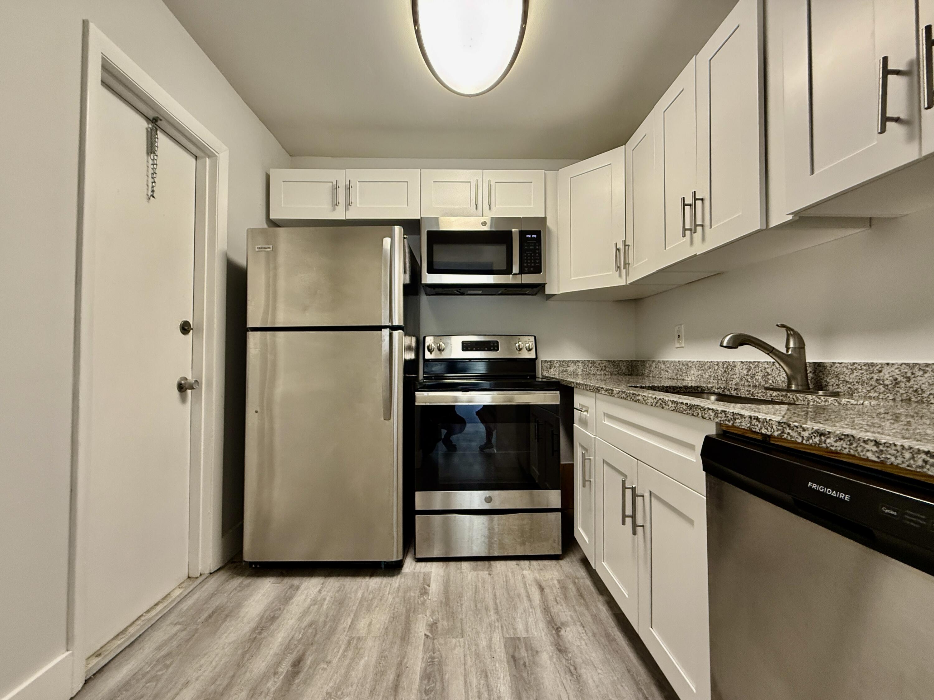 604 Northwest 13th Street, Unit 310 Boca Raton, FL 33486 - Photo 3 of 17 a kitchen with a sink a refrigerator and cabinets