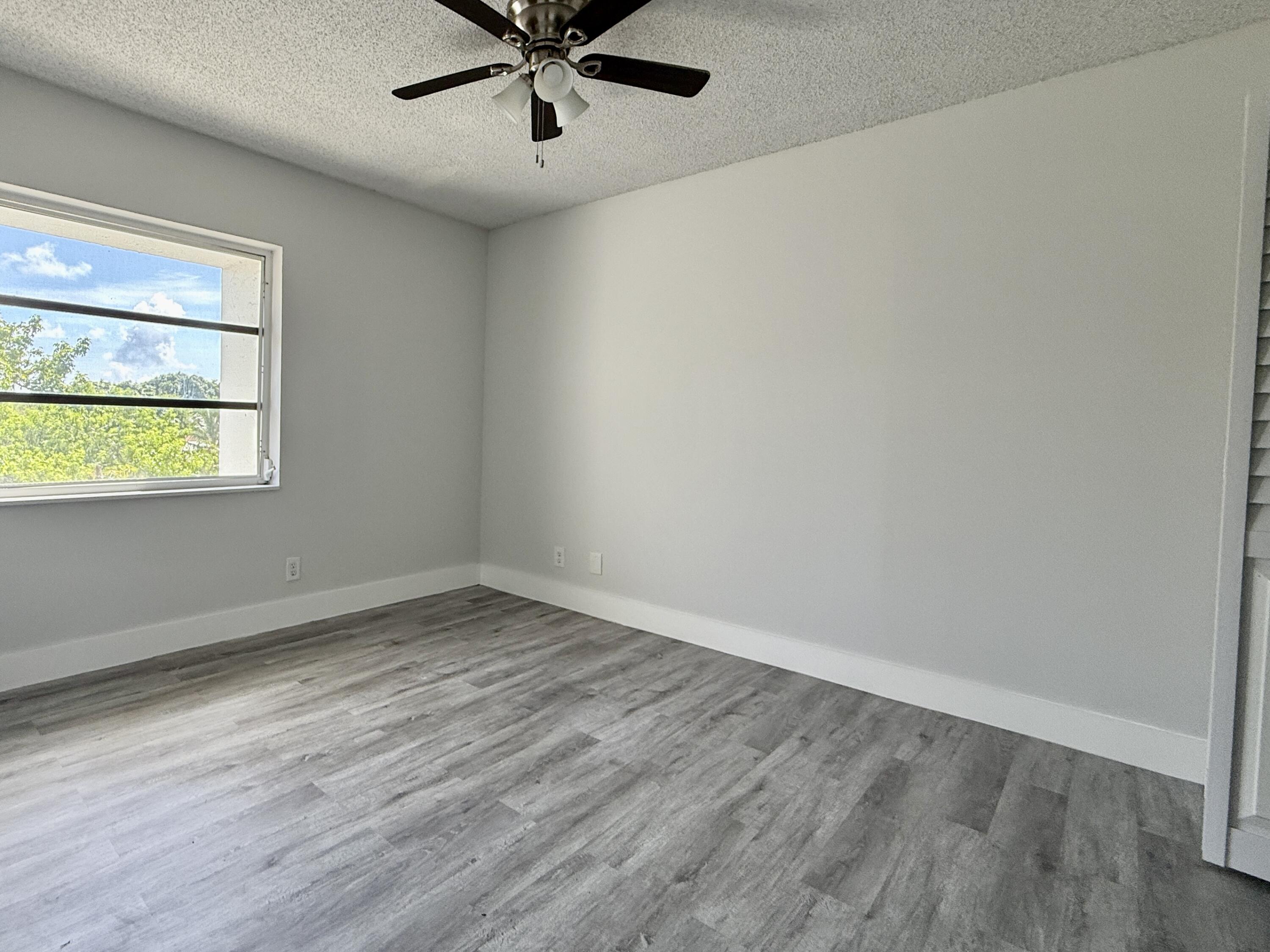 604 Northwest 13th Street, Unit 310 Boca Raton, FL 33486 - Photo 4 of 17 wooden floor in an empty room with a window