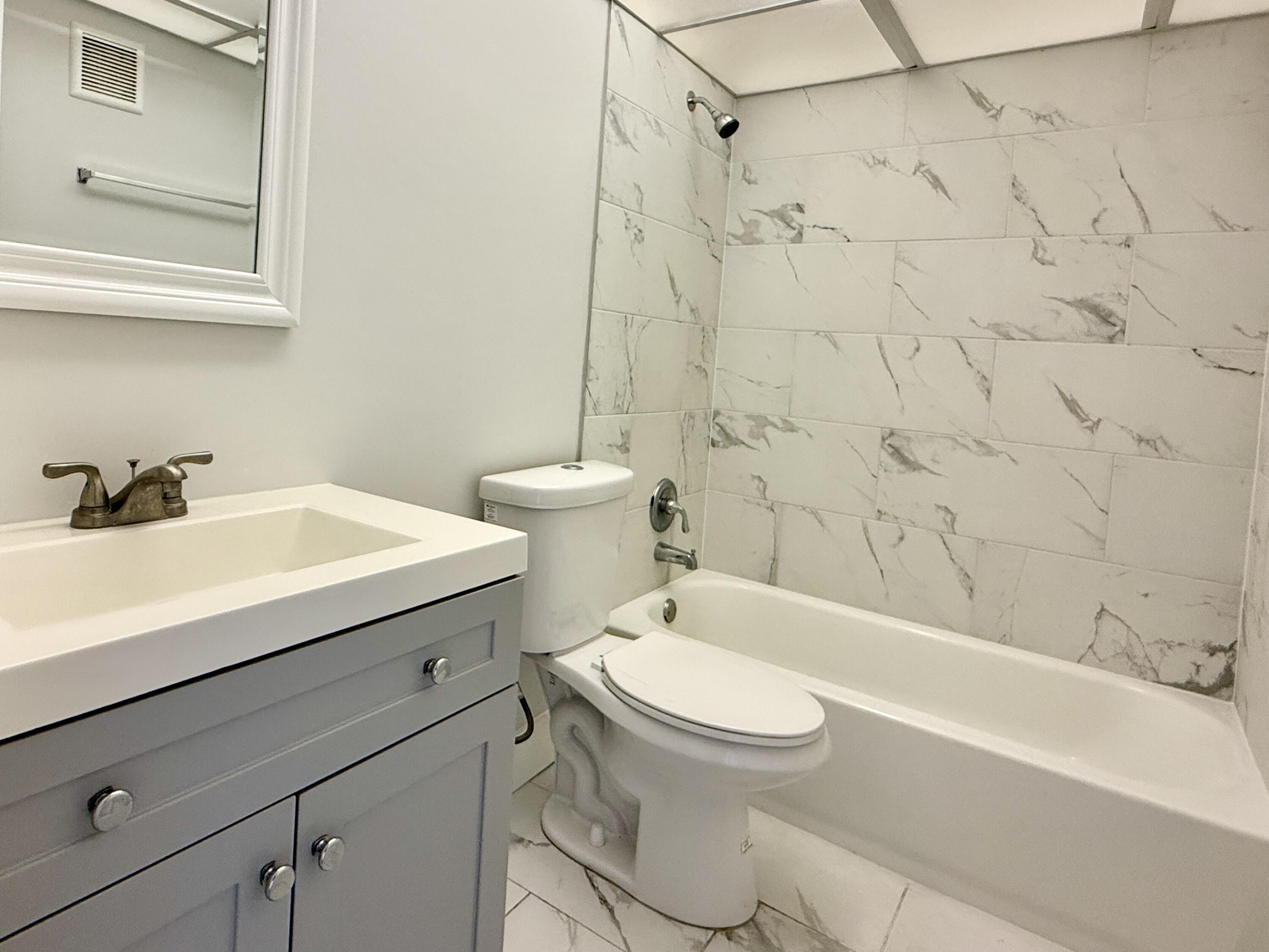 604 Northwest 13th Street, Unit 310 Boca Raton, FL 33486 - Photo 5 of 17 a bathroom with a sink a toilet and a bathtub