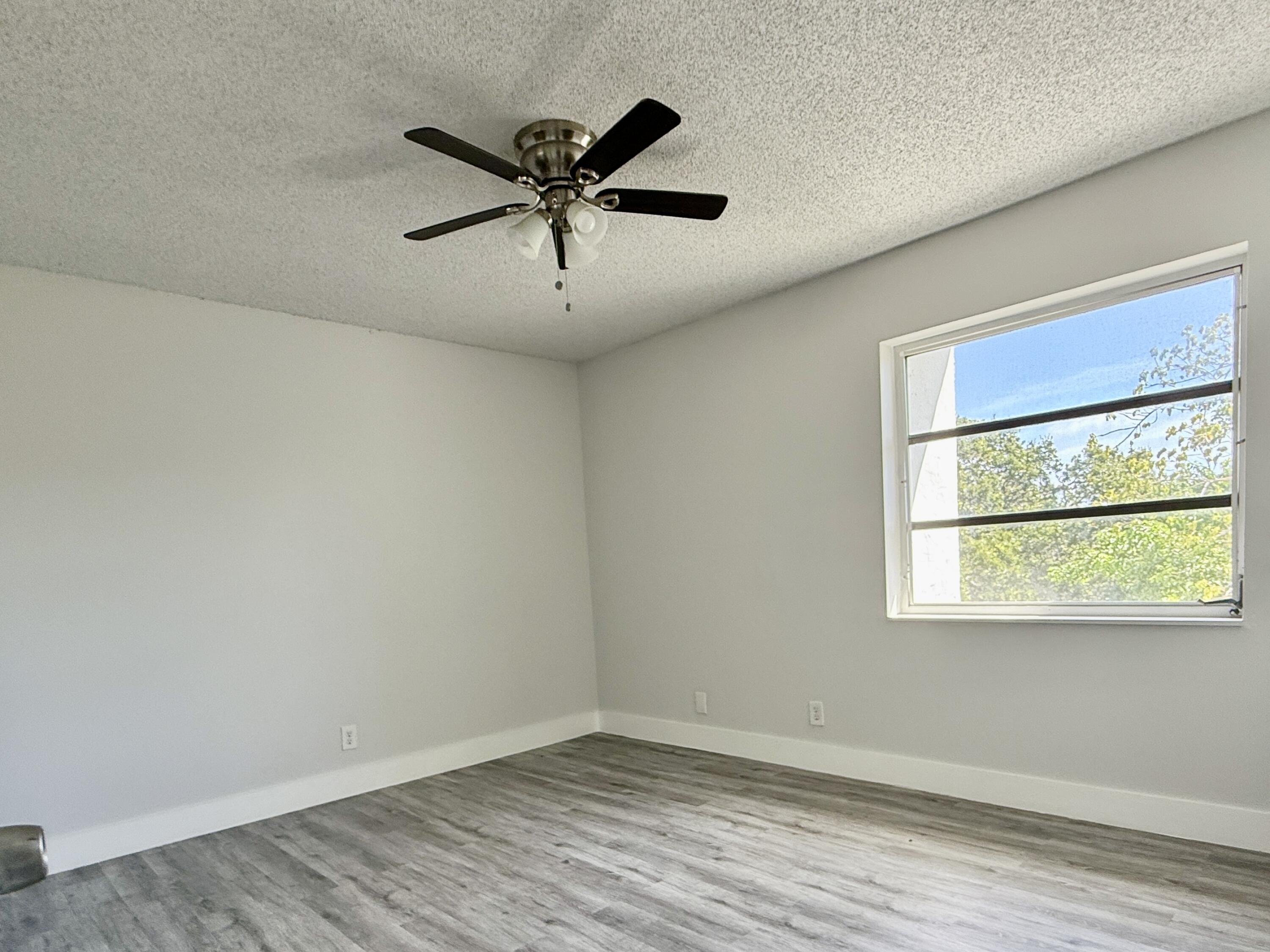 604 Northwest 13th Street, Unit 310 Boca Raton, FL 33486 - Photo 6 of 17 wooden floor in an empty room with a window