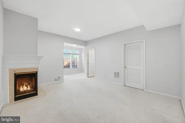 a view of an empty room with a fireplace and a window
