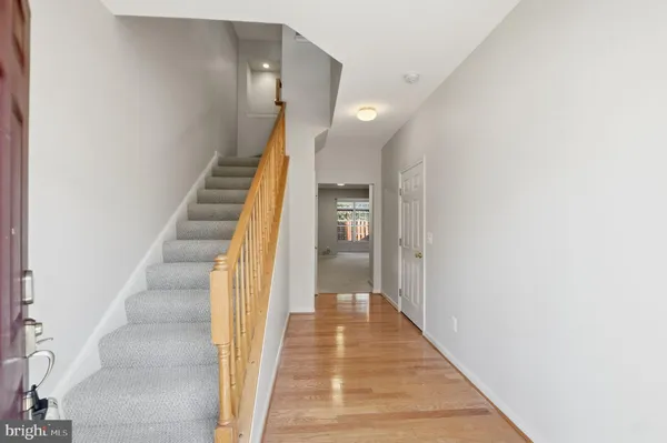 a view of a hallway with wooden floor and entryway