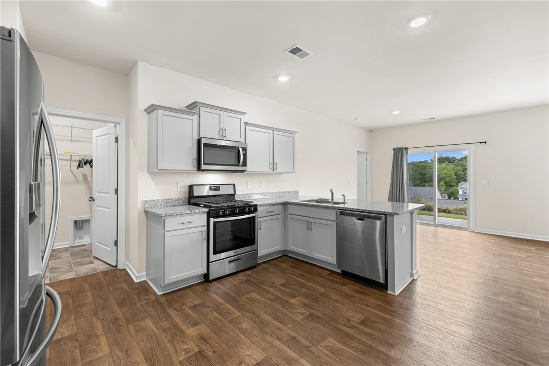233 Millhone Way Pendleton, SC 29670 - Photo 5 of 44 Stainless appliances and granite countertops anchor this modern, light-filled open-plan kitchen.