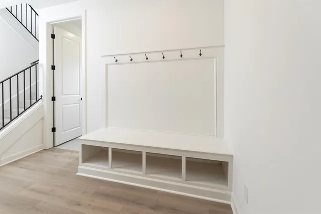 a view of an empty room with wooden floor and cabinet