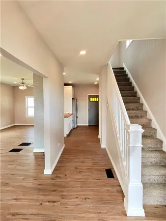 a view of a hallway with wooden floor and staircase