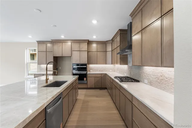 a kitchen with stainless steel appliances granite countertop sink stove and refrigerator