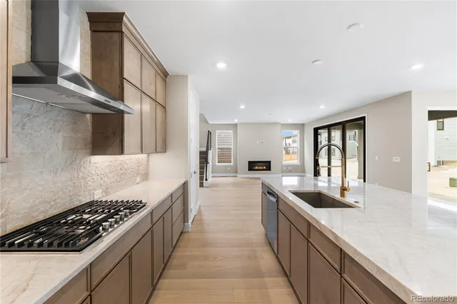 a large kitchen with stainless steel appliances granite countertop a lot of counter space and wooden floor