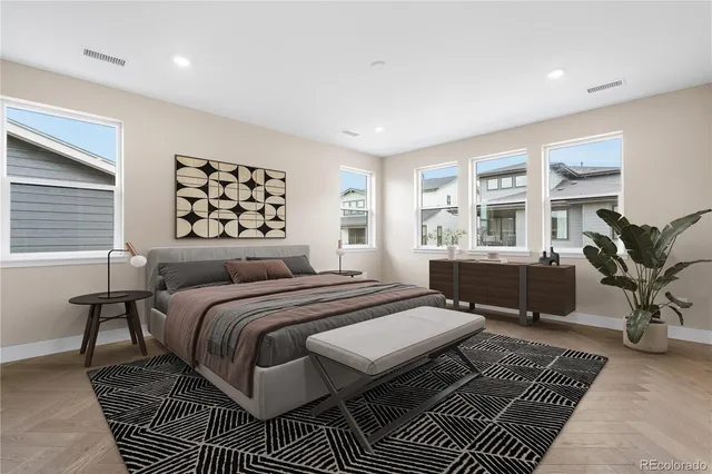 a bedroom with a large bed a potted plant and a window