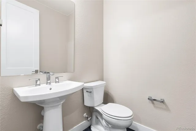 a bathroom with a sink a toilet and mirror