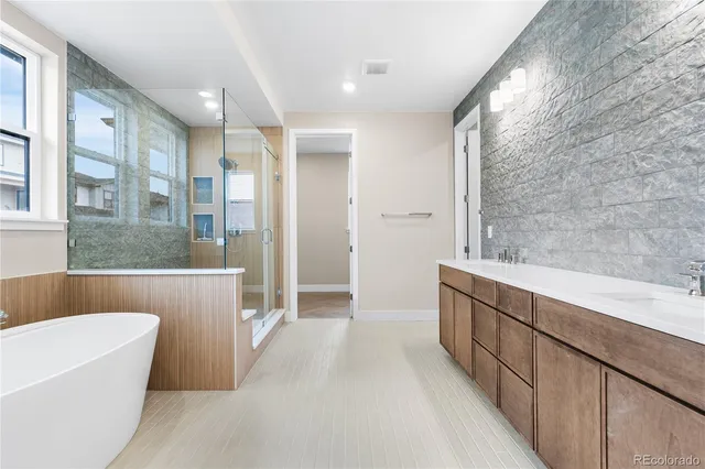 a bathroom with a tub a sink and a large mirror