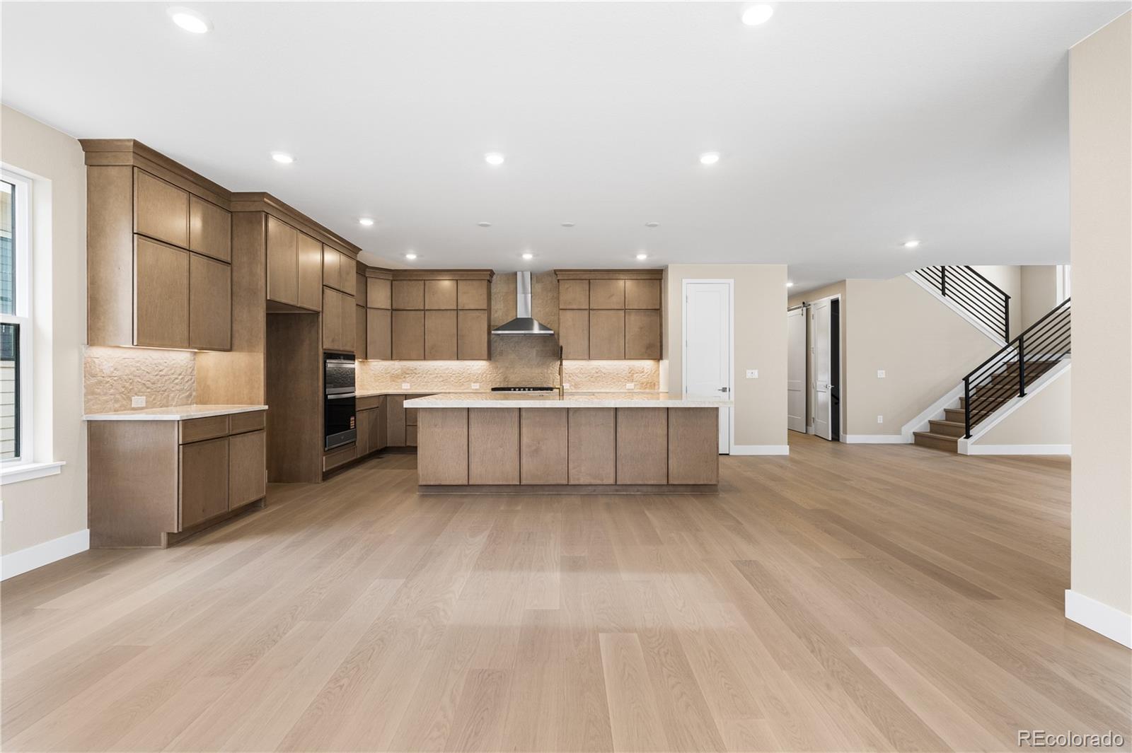 11118 Encantado Trail Lone Tree, CO 80134 - Photo 6 of 50 a view of a kitchen with a sink and dishwasher a refrigerator with wooden floor