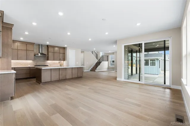 a living room with stainless steel appliances kitchen island granite countertop a sink and cabinets