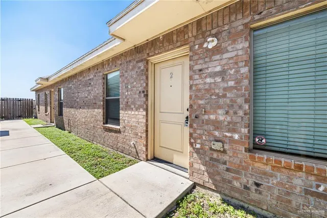 a view of an empty room and chandelier fan
