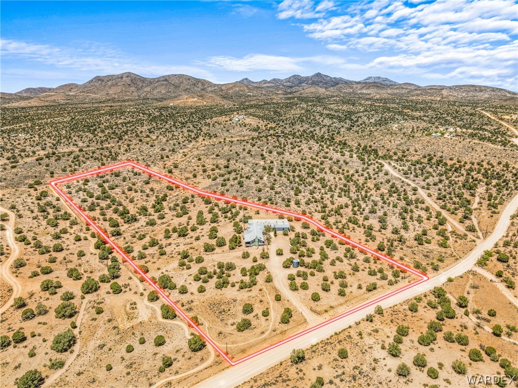 2401 North Stephan Road Kingman, AZ 86401 - Photo 91 of 92 Expansive desert property featuring a single-story residence with a light-colored roof, surrounded by numerous mature desert trees and natural terrain