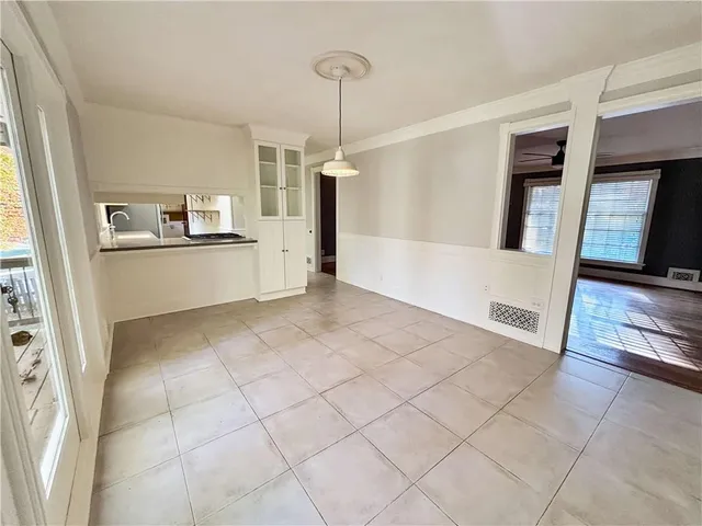 a large white kitchen with a sink a refrigerator and window