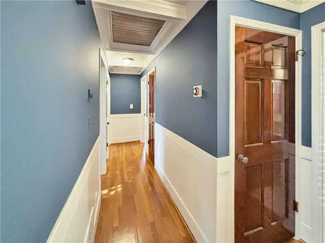 a view of a hallway with wooden floor and staircase
