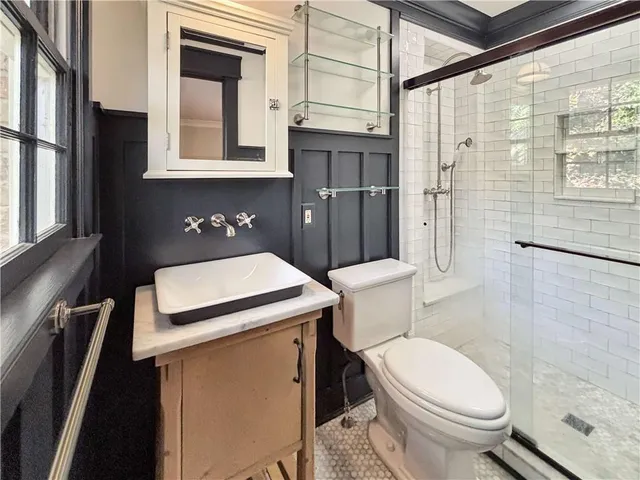 a bathroom with a sink a toilet and shower