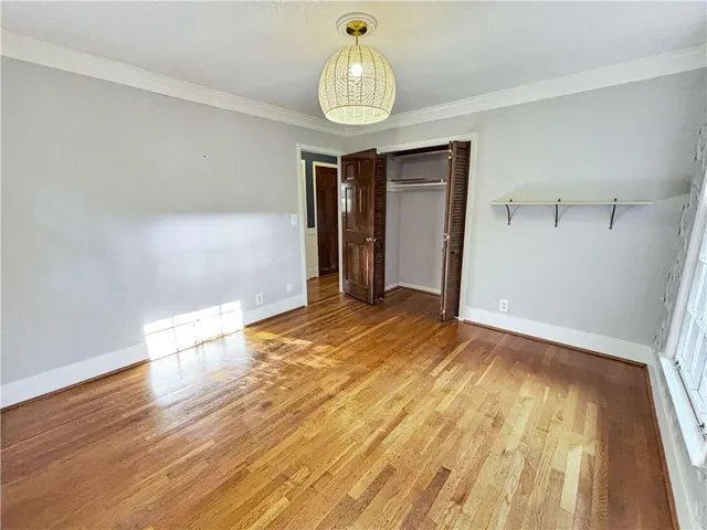 a view of empty room with wooden floor