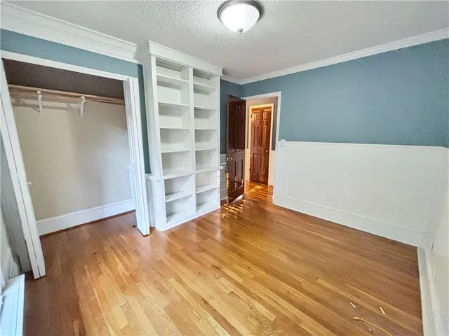 an empty room with wooden floor and closet