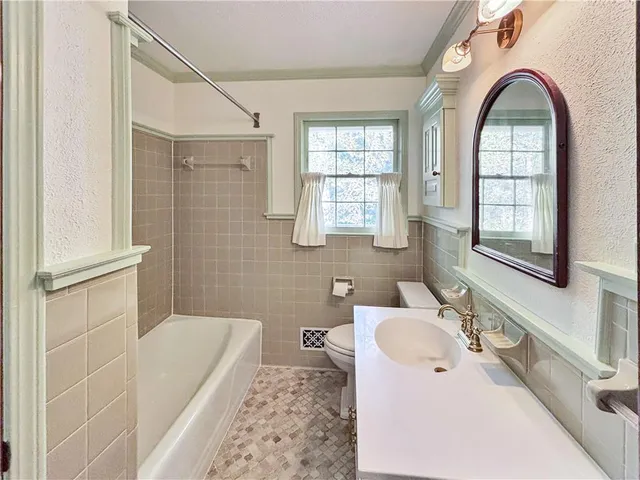 a bathroom with a granite countertop sink a large mirror and a bathtub