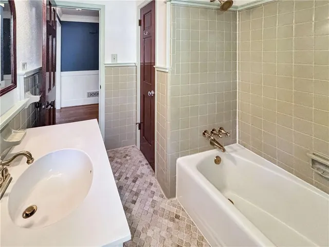 a bathroom with a tub a sink and mirror
