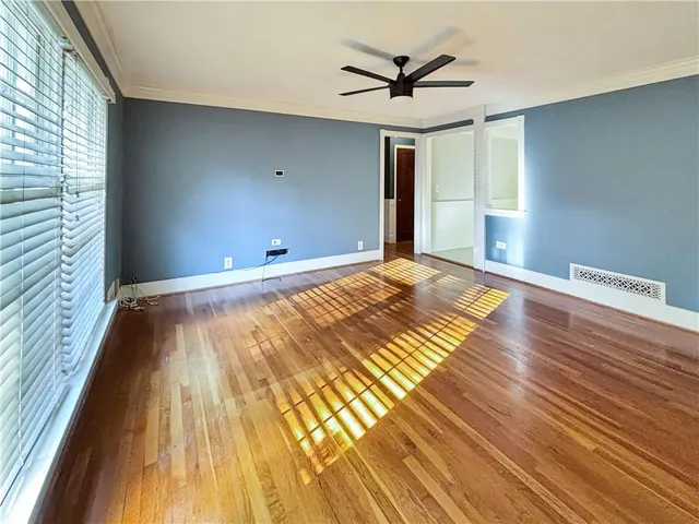 a view of a room with wooden floor and window