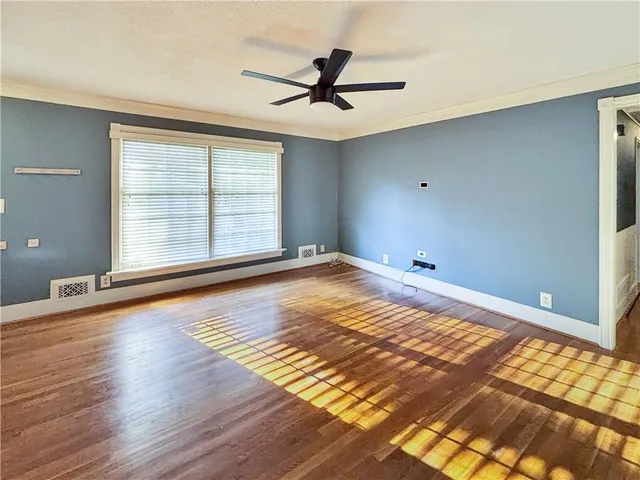 a view of a room with wooden floor and white walls