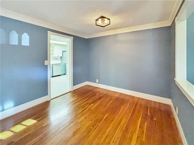 a view of empty room with wooden floor