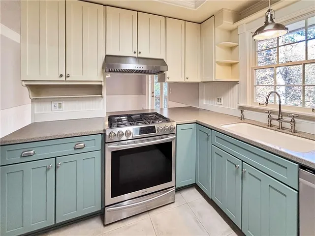 a kitchen with granite countertop white cabinets and white stainless steel appliances