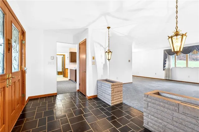 a view of an empty room with wooden floor and windows