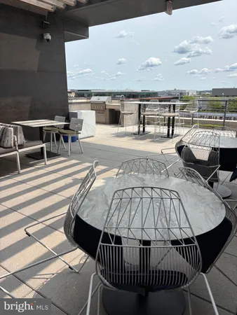 a view of a balcony with two chairs and a barbeque