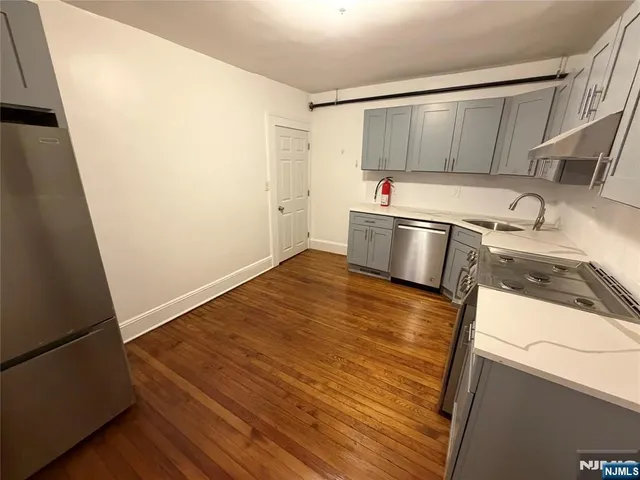 a view of a kitchen with wooden floor and electronic appliances