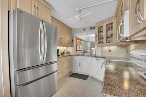 a kitchen with stainless steel appliances a refrigerator sink and cabinets