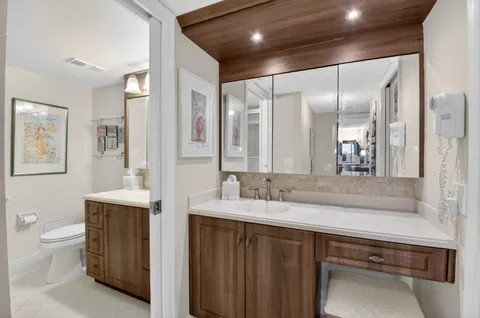 a bathroom with a sink a toilet and a large mirror