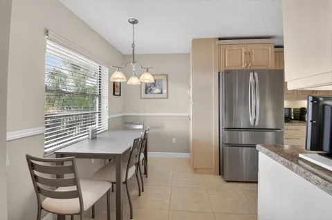 a kitchen with a refrigerator a table and chairs