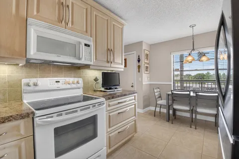 a kitchen with white cabinets and appliances