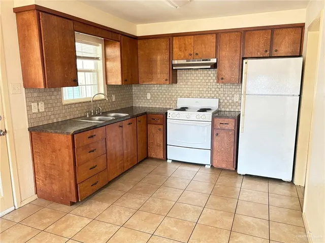 a kitchen with stainless steel appliances granite countertop a stove a refrigerator a sink and dishwasher