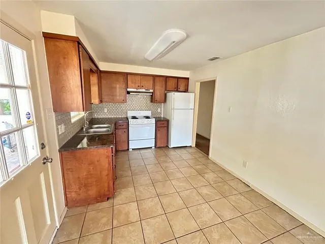 a kitchen with stainless steel appliances granite countertop a refrigerator stove and sink