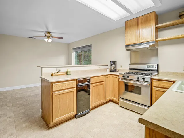 a kitchen with granite countertop a sink stainless steel appliances and cabinets