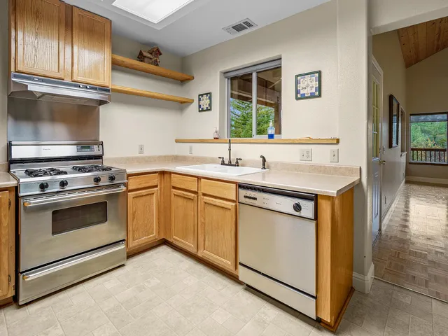 a kitchen with granite countertop a sink stainless steel appliances and cabinets
