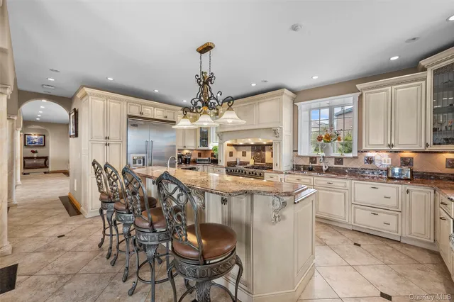 a kitchen with stainless steel appliances granite countertop a stove refrigerator and cabinets