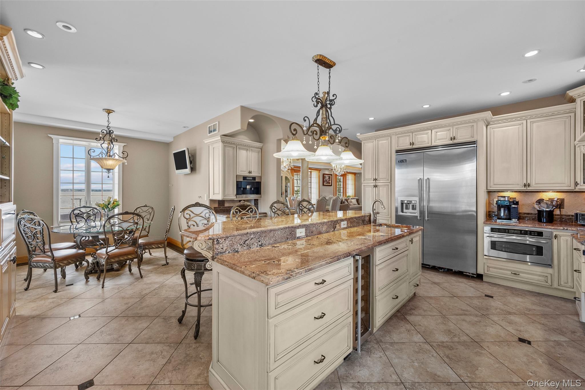 3407 Country Club Road Bronx, NY 10465 - Photo 17 of 34 Kitchen with a breakfast bar area, light stone counters, recessed lighting, stainless steel appliances, and cream cabinetry
