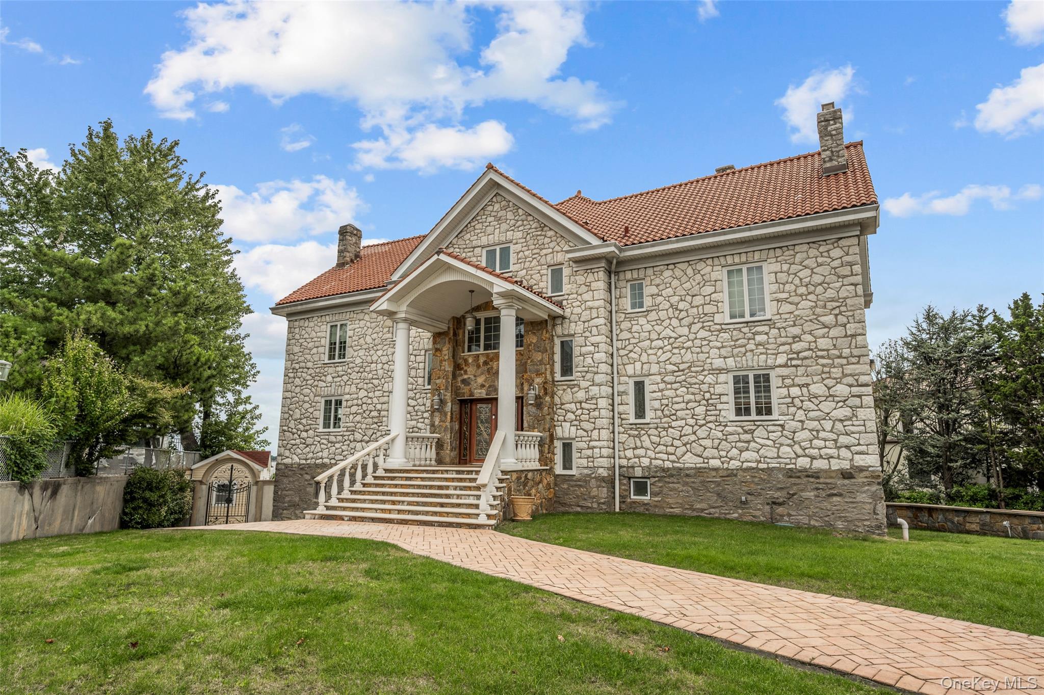 3407 Country Club Road Bronx, NY 10465 - Photo 2 of 34 View of front of property featuring stone siding, a chimney, a front lawn, and a tile roof