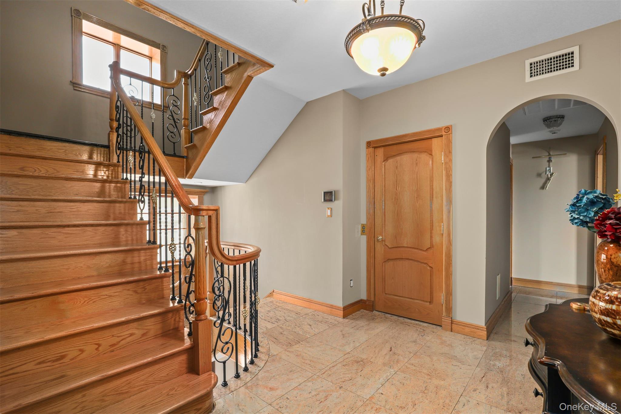 3407 Country Club Road Bronx, NY 10465 - Photo 21 of 34 Entryway with arched walkways, visible vents, stairway, and baseboards