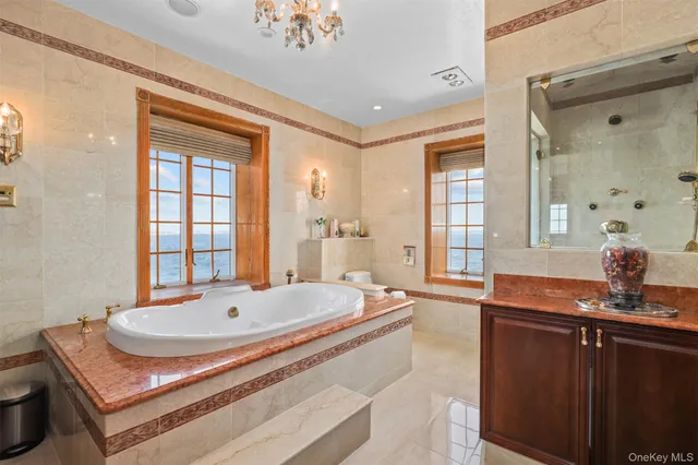 a spacious bathroom with a tub sink and mirror