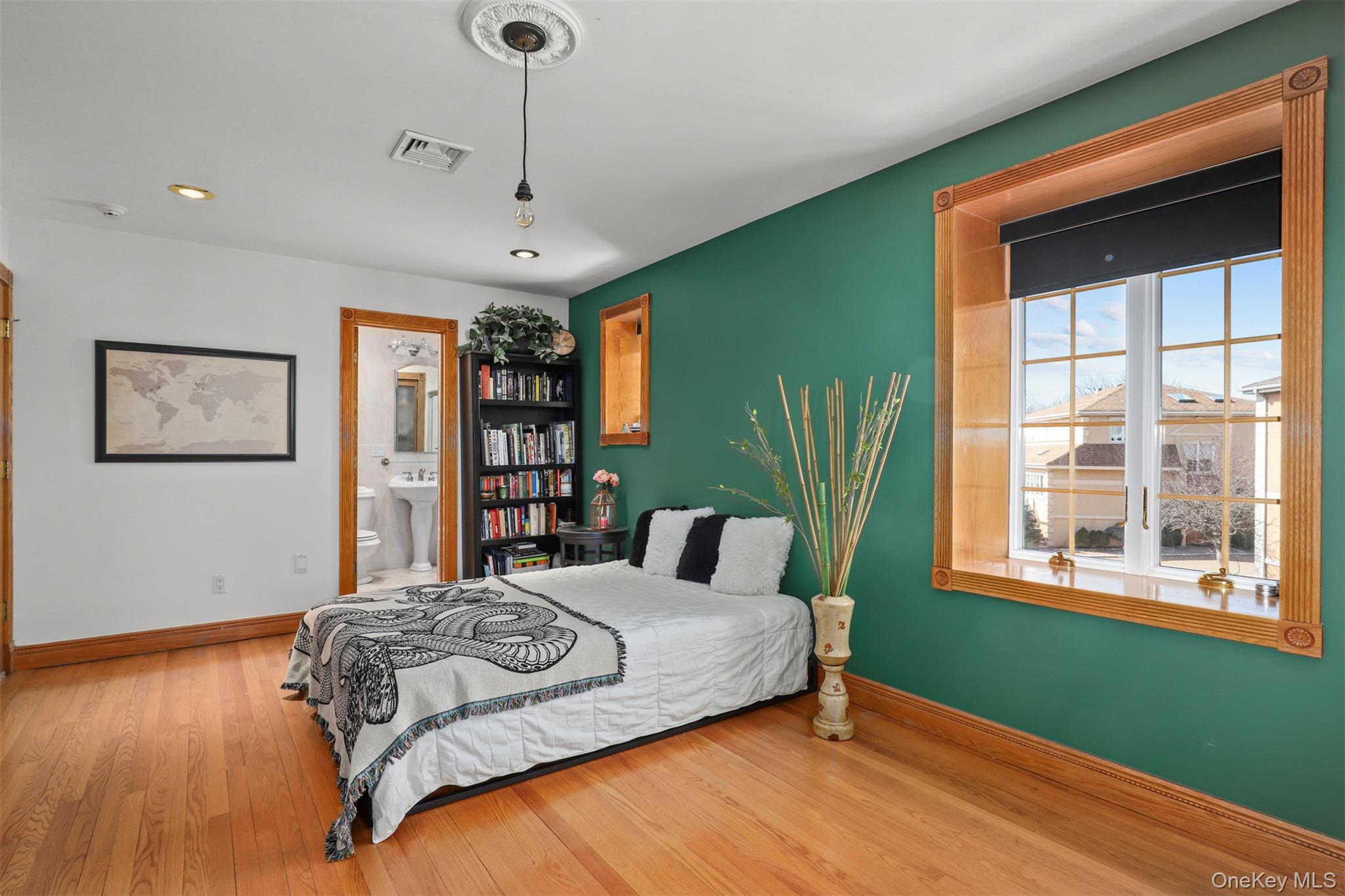 3407 Country Club Road Bronx, NY 10465 - Photo 26 of 34 Bedroom with connected bathroom, visible vents, baseboards, and wood finished floors