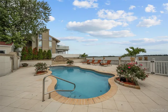 a view of a swimming pool with a patio and a fire pit