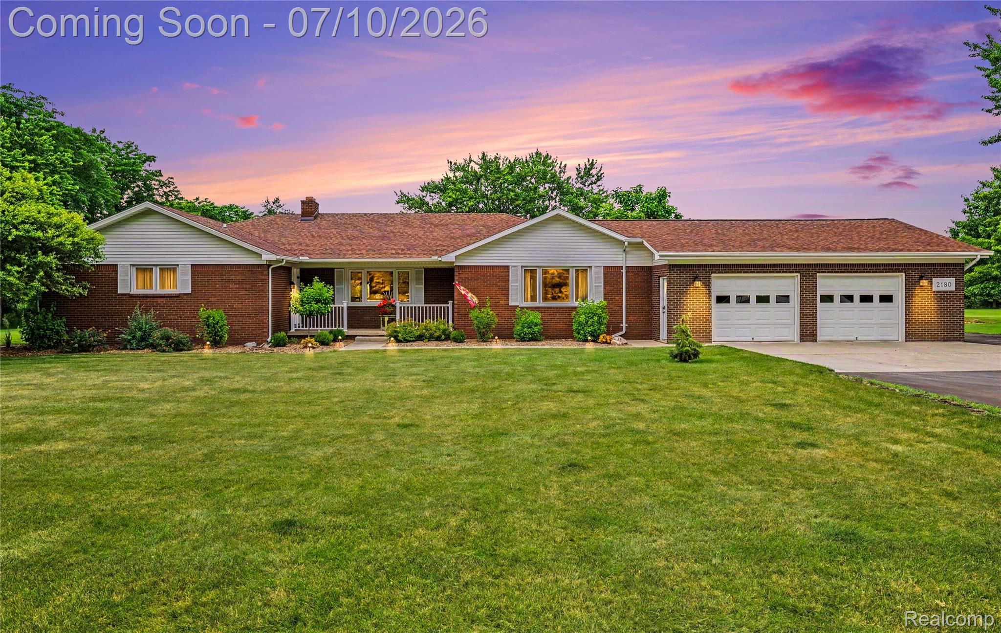2180 Hurst Road St. Clair, MI 48079 - Photo 1 of 39 Brick ranch-style home featuring a covered front porch with white railings, a brown shingle roof, and a two-car garage with white paneled doors